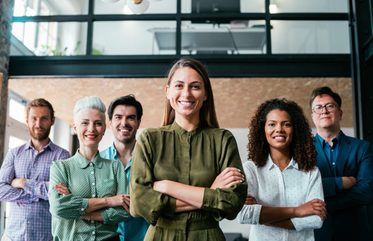 6 adultes alignés bras croisés et souriants