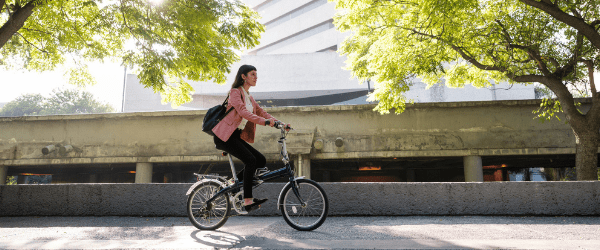 Femme sur un vélo montrant les bienfaits du forfait mobilités durables