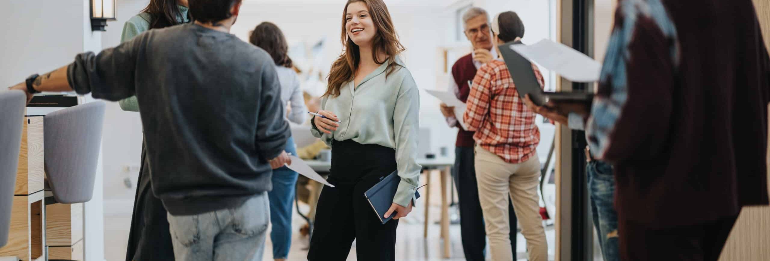 Businesspeople in a modern office space are engaging in a relaxed, informal networking session, exuding a friendly and collaborative atmosphere.