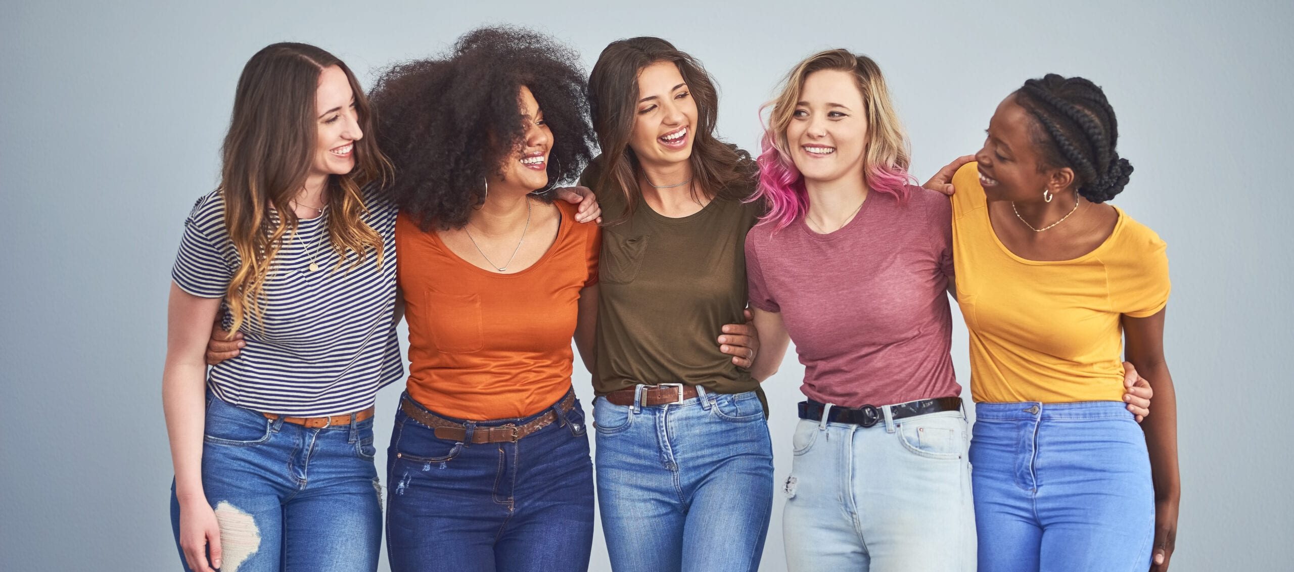 5 femmes bras dessus bras dessous avec des t-shirts de toutes les couleurs