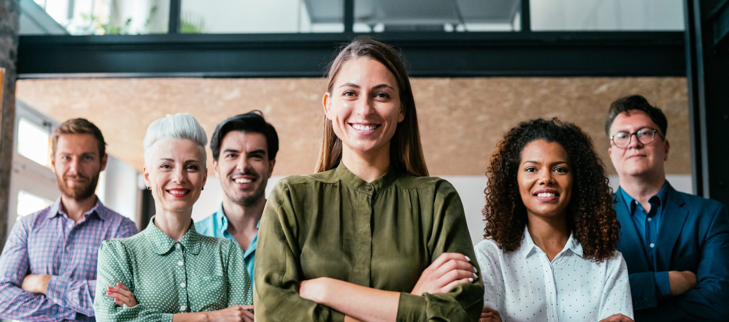 6 adultes alignés bras croisés et souriants